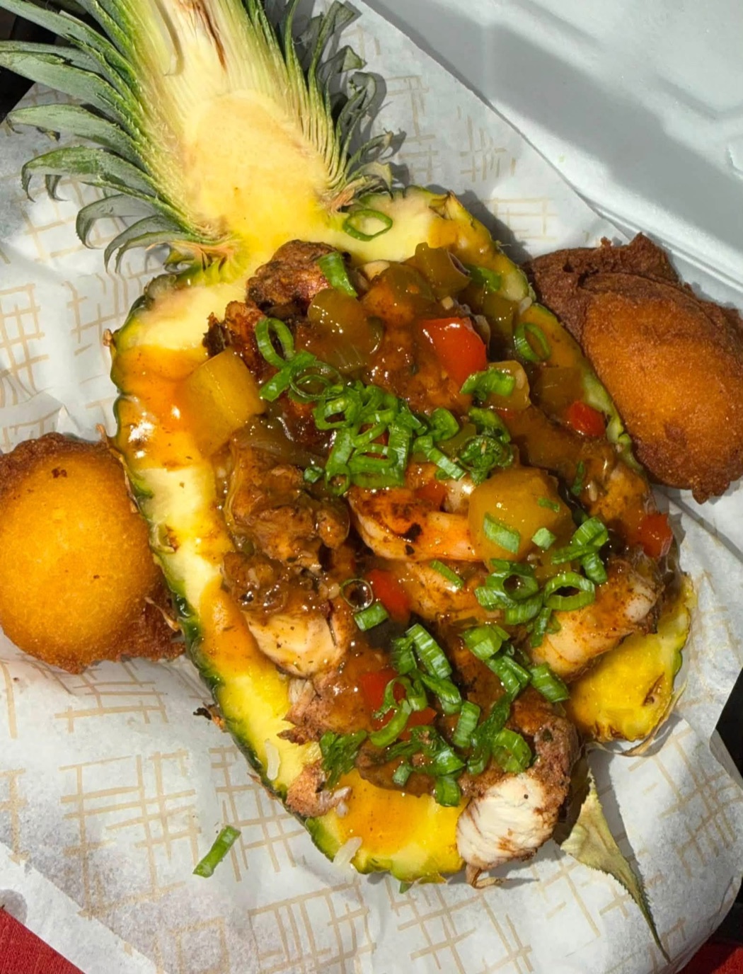 Chef Stephon Sunday Dinner served in a pineapple with grilled meats, peppers and fresh garnish