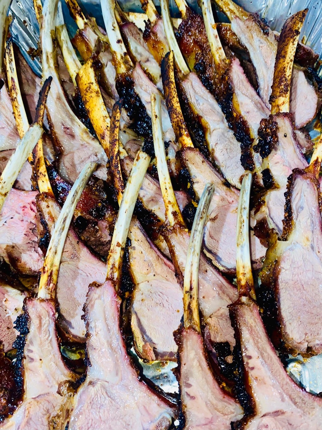 A carved rack of lamb arranged on a serving tray