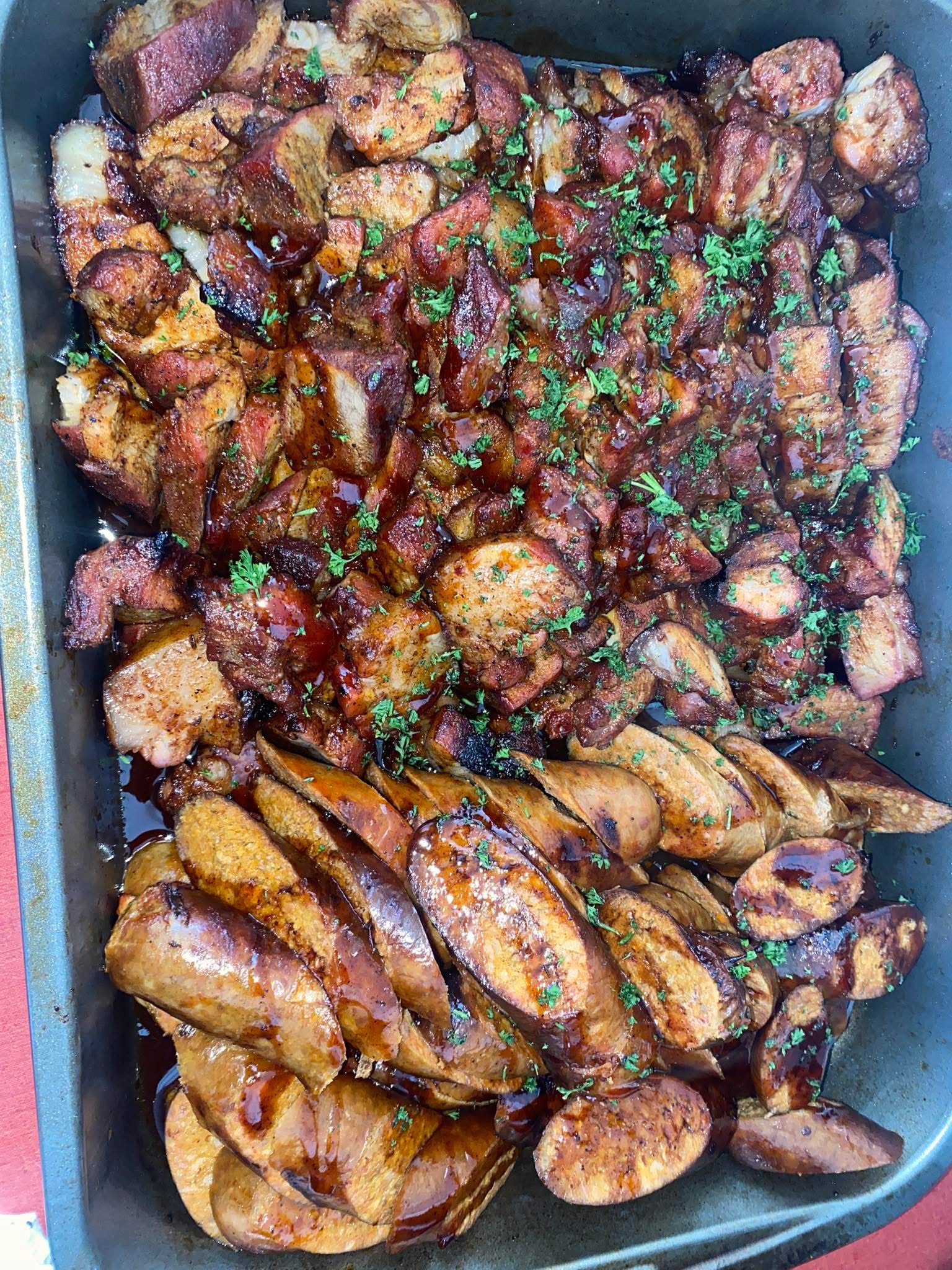 A full pan of smoked barbecue chicken quarters, glazed and ready for service